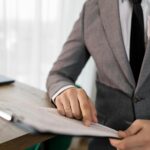 Business professional in suit reviewing important documents at the office.